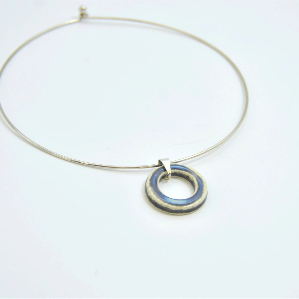 Colgante de cerámica circular perla y gris con cordón de cuero y cierre de plata, joyería artesanal de Maia Cerámica