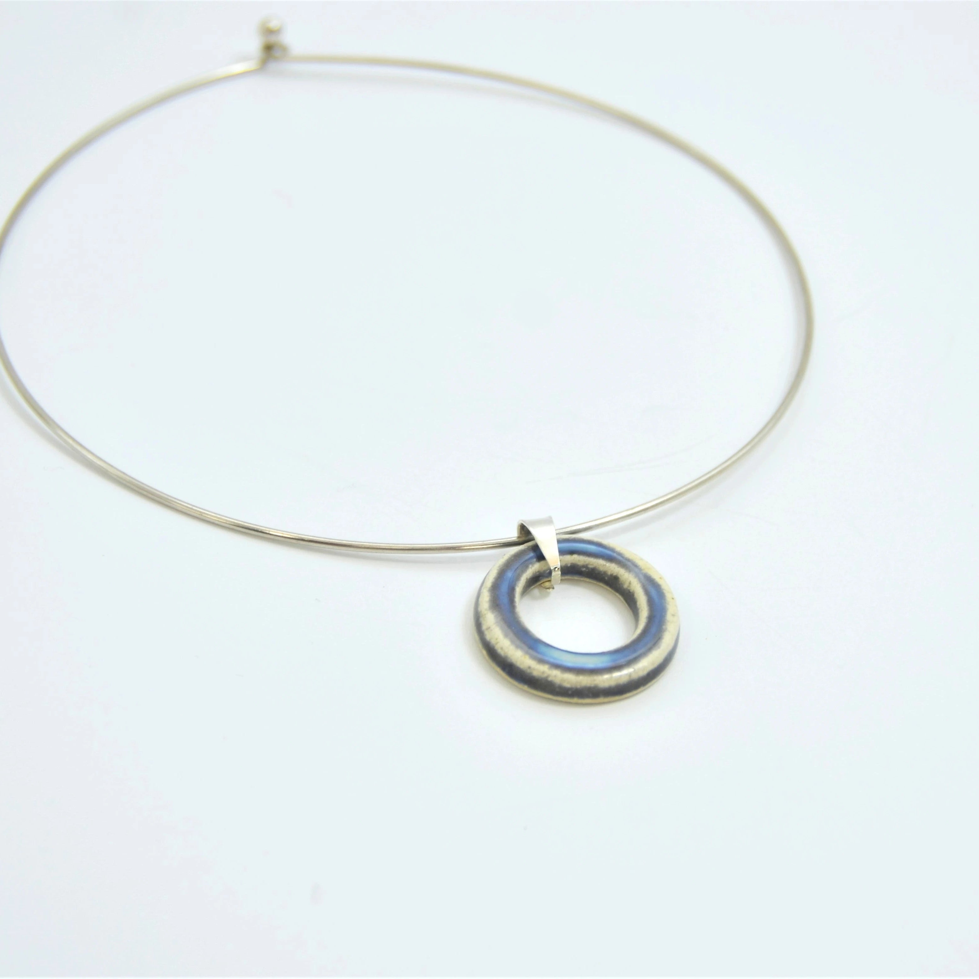 Colgante de cerámica circular perla y gris con cordón de cuero y cierre de plata, joyería artesanal de Maia Cerámica