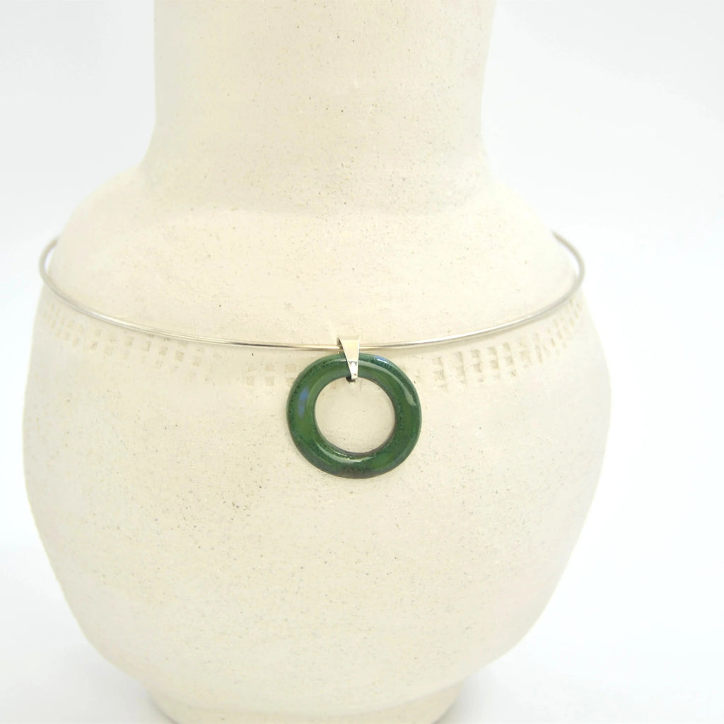 Colgante circular artesanal de cerámica verde azulado con enganche de plata, hecho a mano por Maia Cerámica