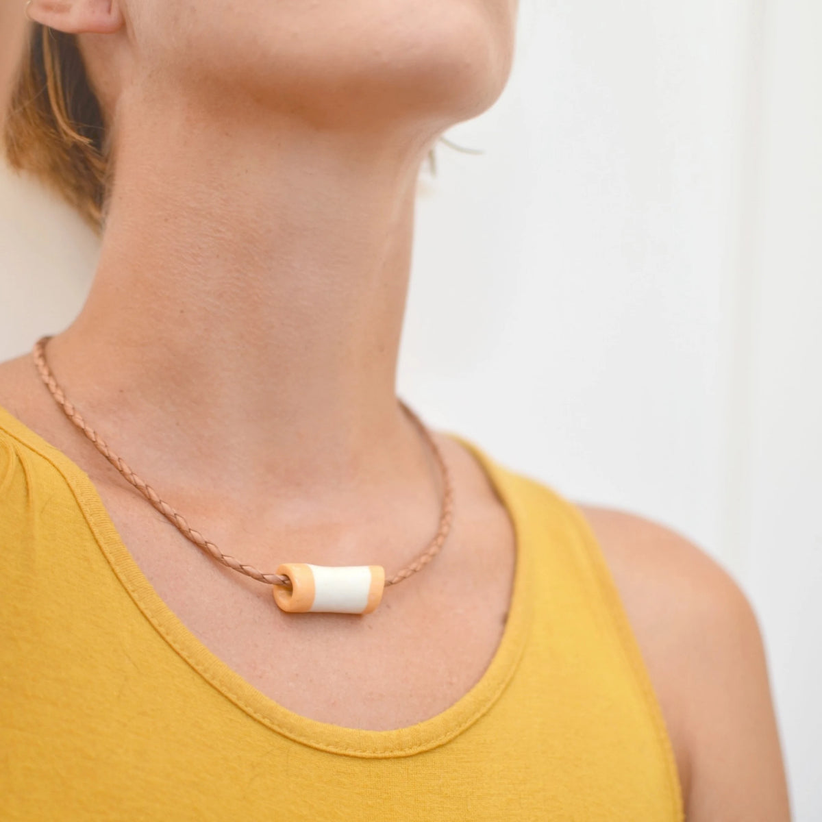 collar-tubo-mostazayblanco-regalo-ceramica-artesanal-cuerotrenzado-plata 2.webp