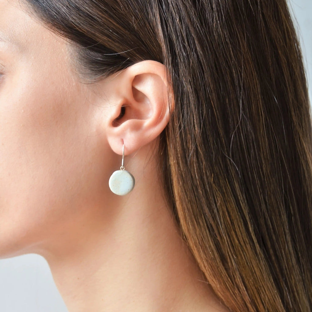 Pendientes artesanales de cerámica luna blanco con engarce de plata, hecho a mano por Maia Cerámica