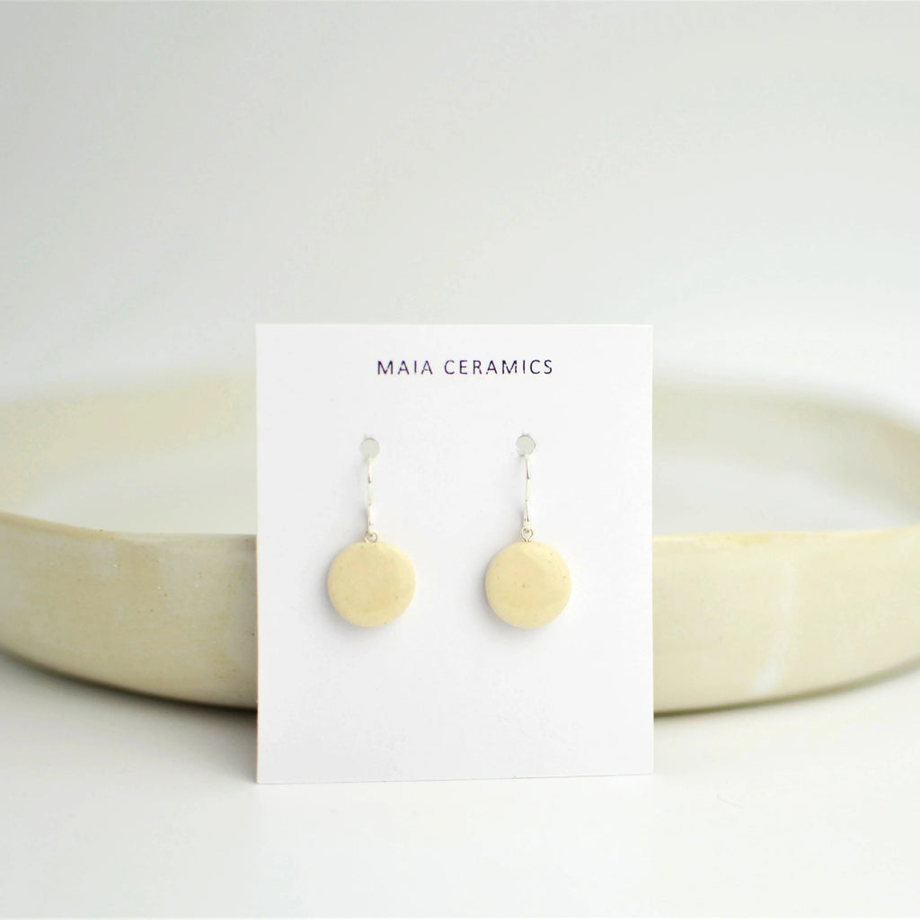 Par de pendientes artesanales de cerámica con diseño de luna en blanco y engarce de plata, Maia Cerámica