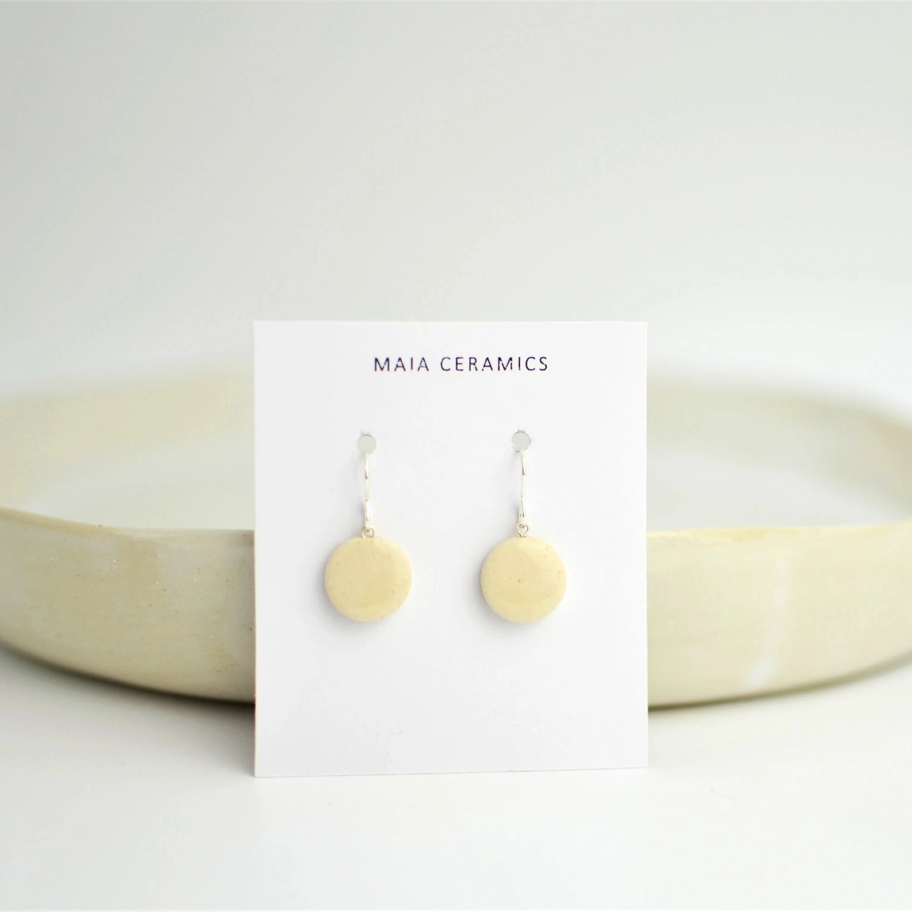 Par de pendientes artesanales de cerámica con diseño de luna en blanco y engarce de plata, Maia Cerámica