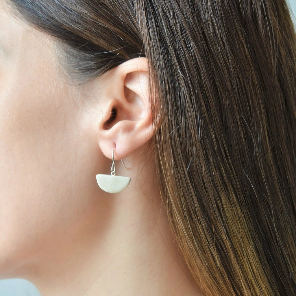 Pendientes artesanales de cerámica media luna blanco con enganche de plata, hecho a mano por Maia Cerámica