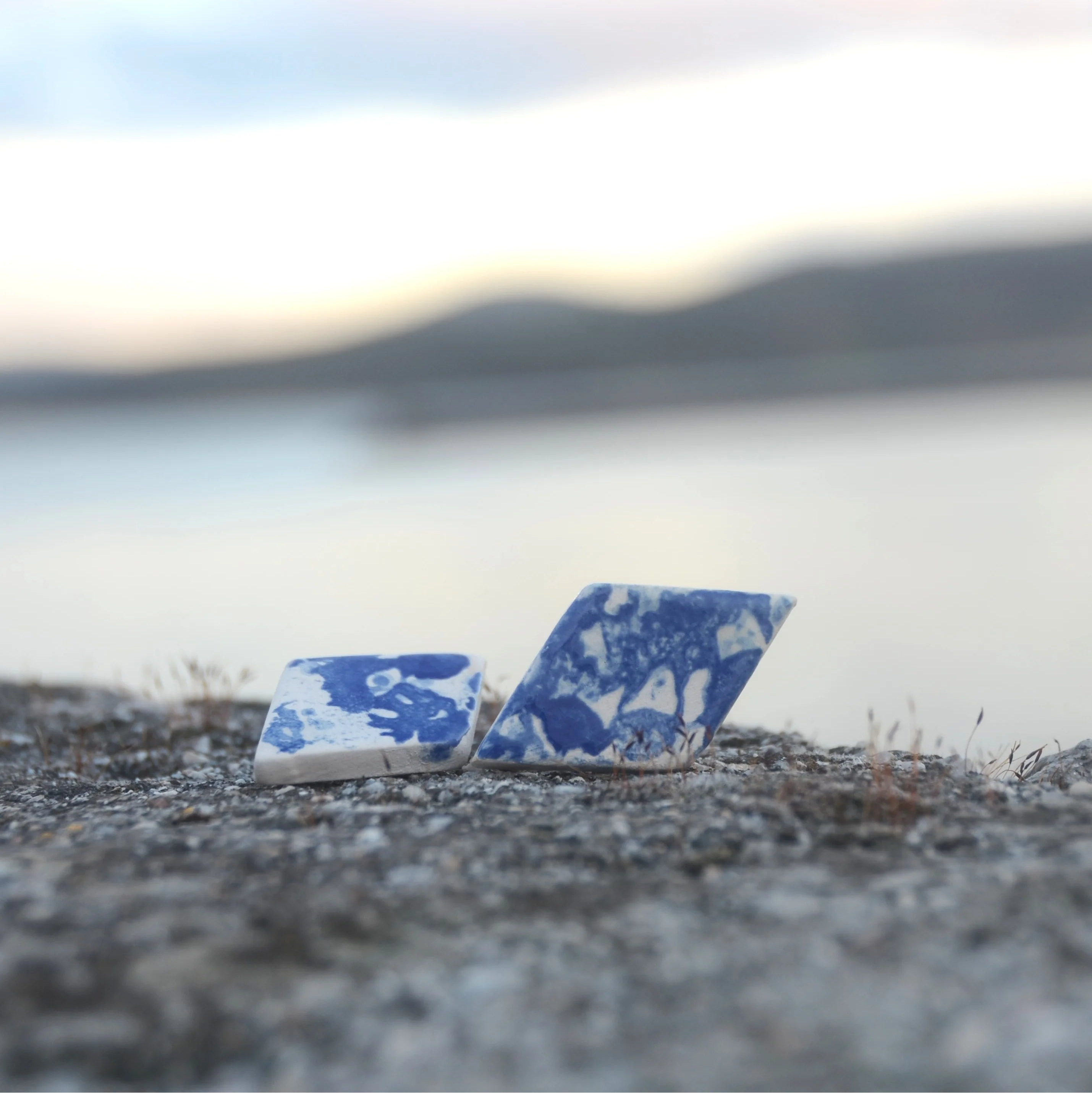 Detalle de pendientes de cerámica rombo azul con motivo de encaje gallego hecho a mano, joyería artesanal de Maia Cerámica