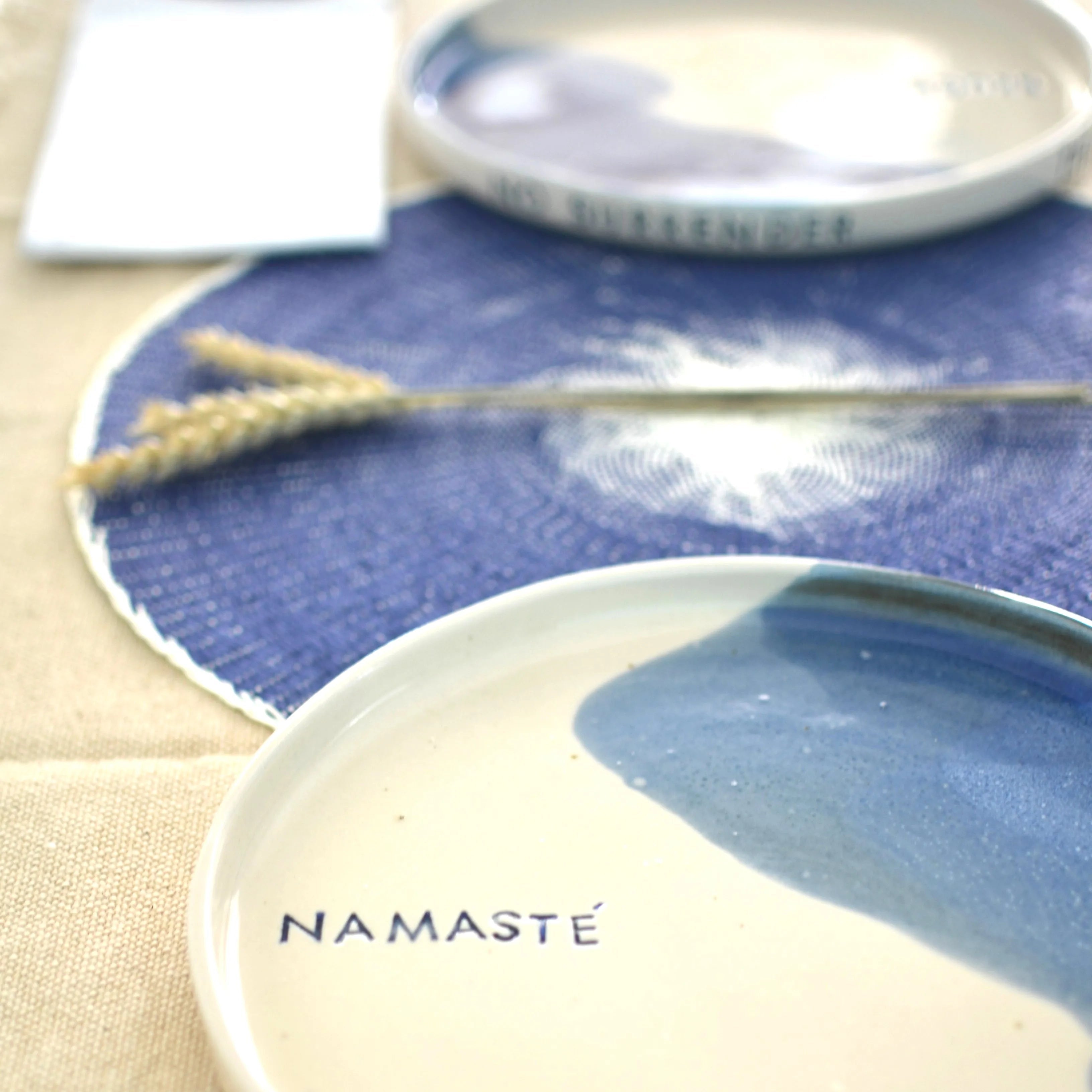 Detalle palabra Namasté en plato cerámica artesanal azul hecho a mano - Maia Artesanía Cerámic