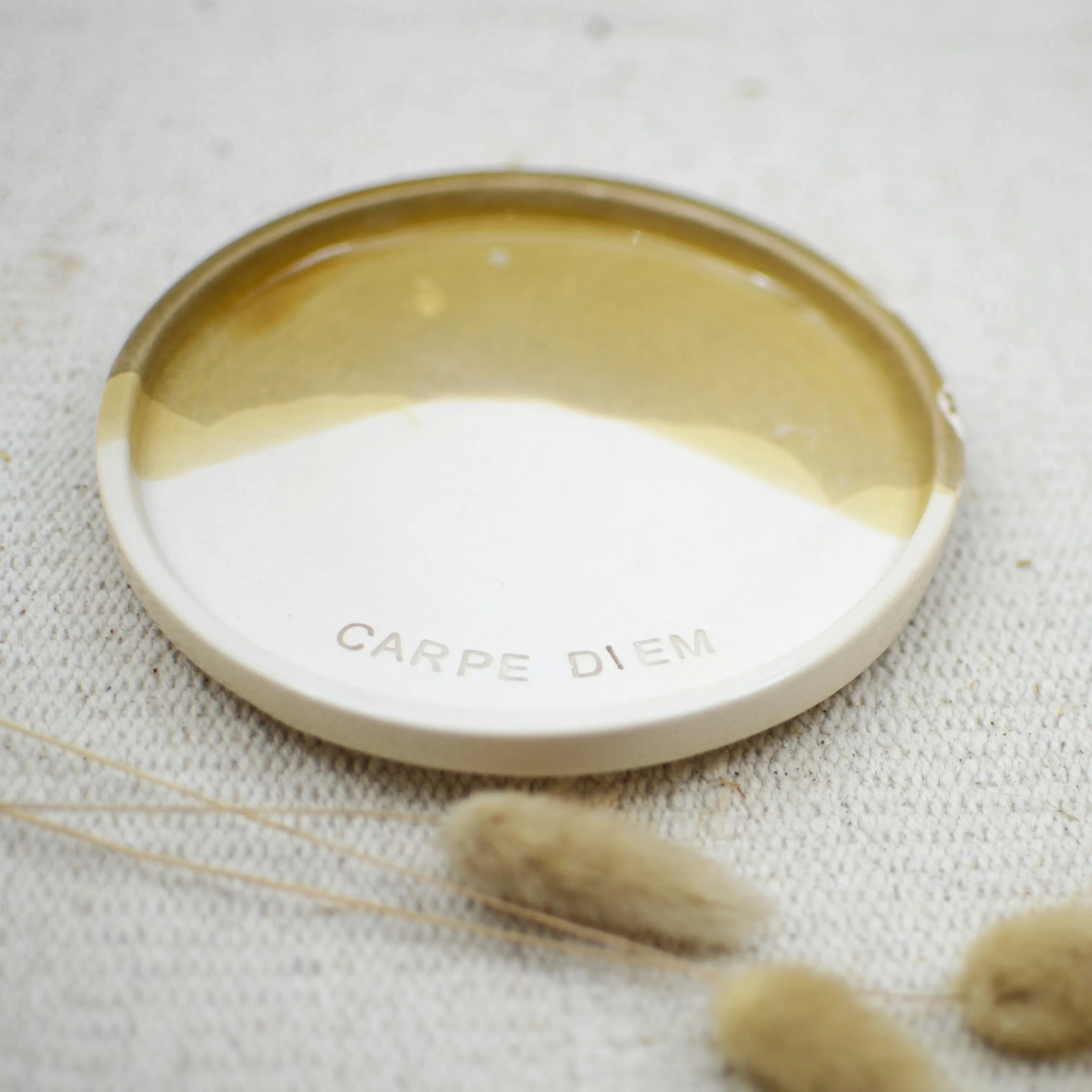 Detalle mensaje Carpe Diem plato cerámica artesanal blanco y arena hecho a mano 17cm - Maia Artesanía Cerámica