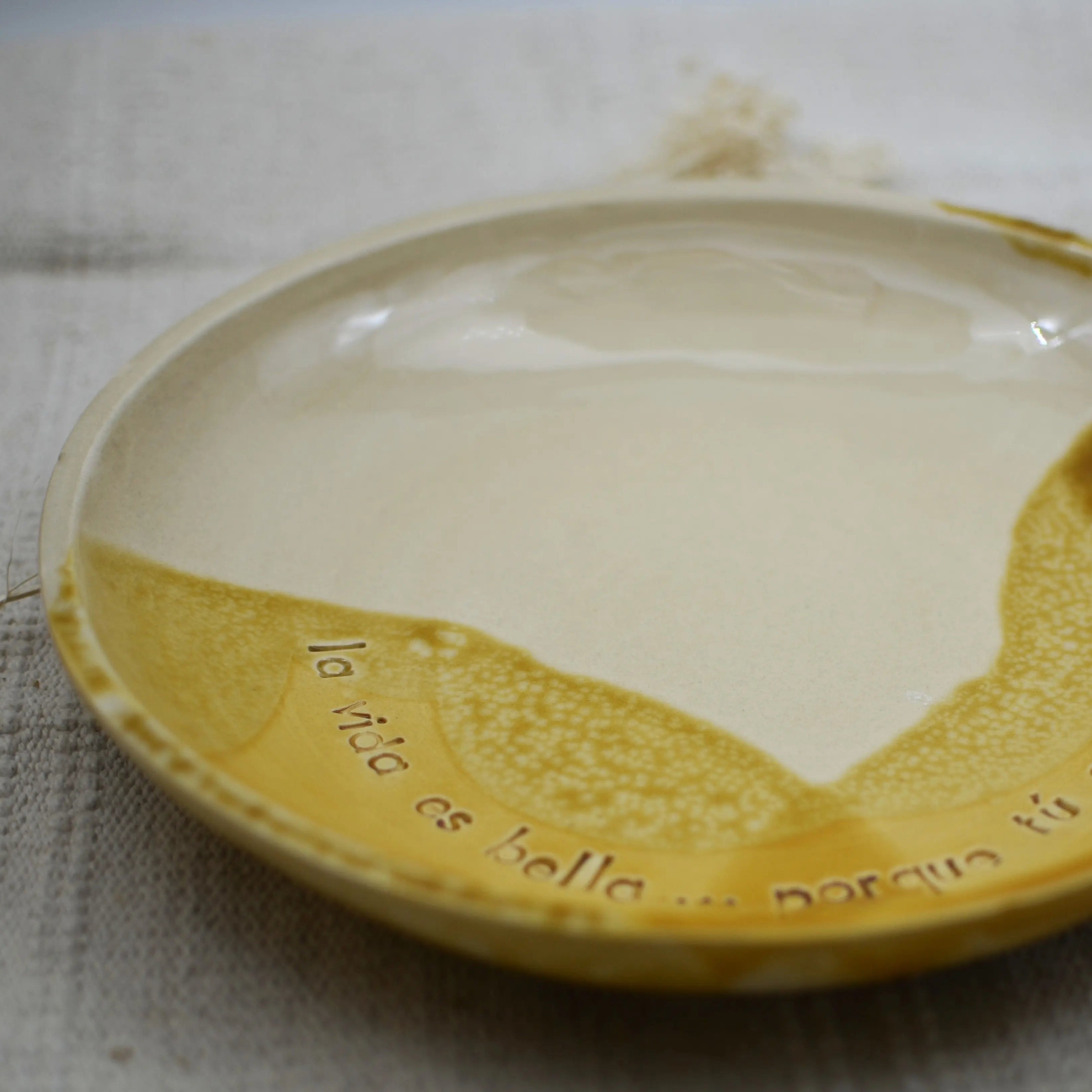 Detalle mensaje La vida es bella porque tú estás en ella plato cerámica artesanal blanco y miel hecho a mano 25cm - Maia Artesanía Cerámica