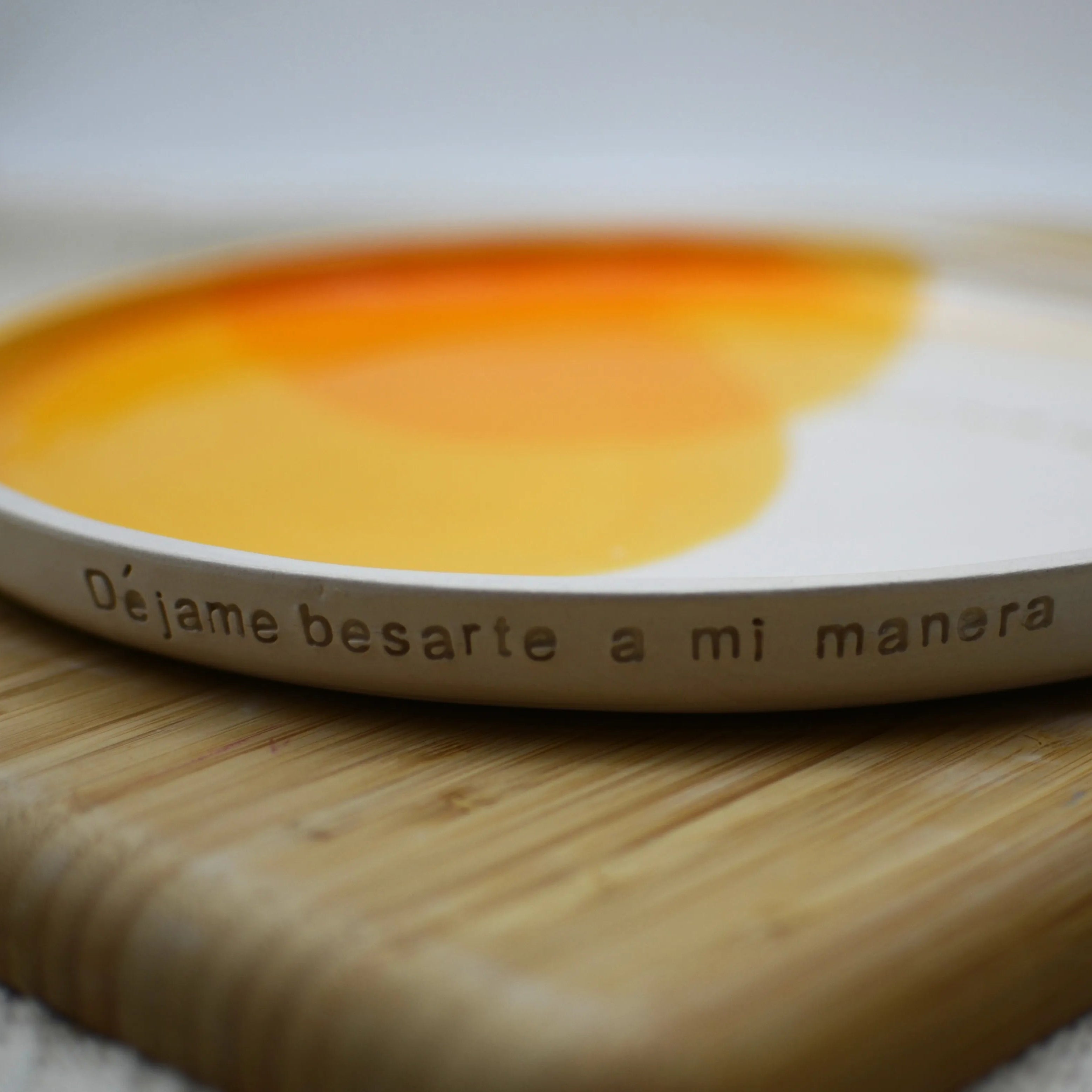 Plato cerámica artesanal Déjame abrazarte para siempre sobre superficie natural blanco y naranja 25cm - Maia Artesanía Cerámica