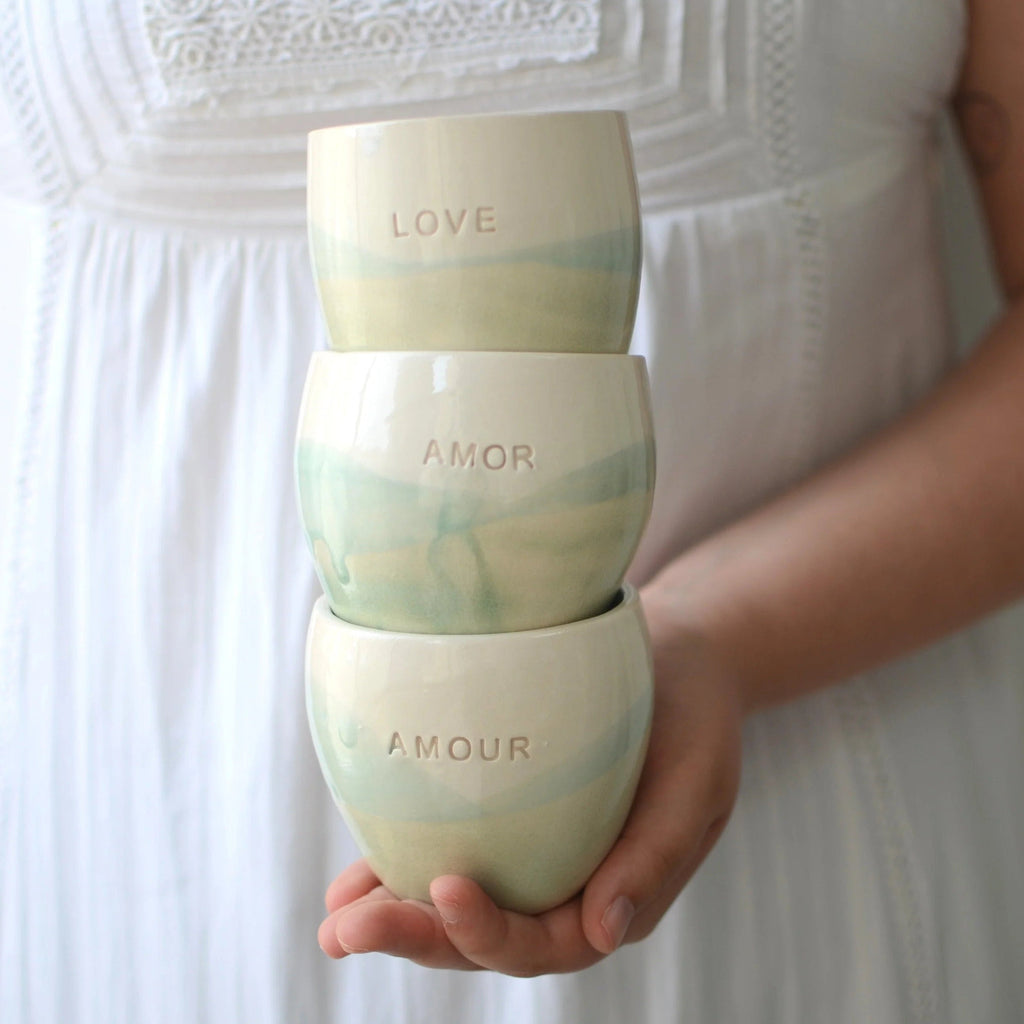 Conjunto de 3 vasos de cerámica artesanal en blanco y turquesa con las palabras Amor, Love y Amour, hechos a mano por Maia Artesanía Cerámica